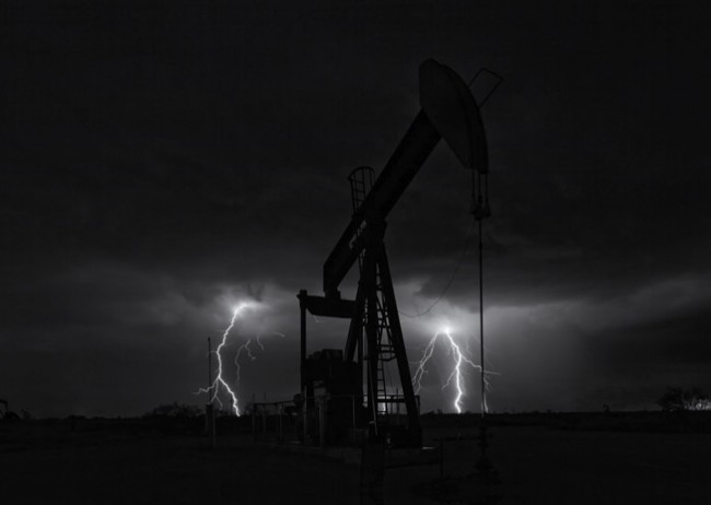 A lone pumpjack is flanked by twin lightning strikes at 3:36am during a rare October electrical storm near Denver City, Texas. By Robert D. Flaherty