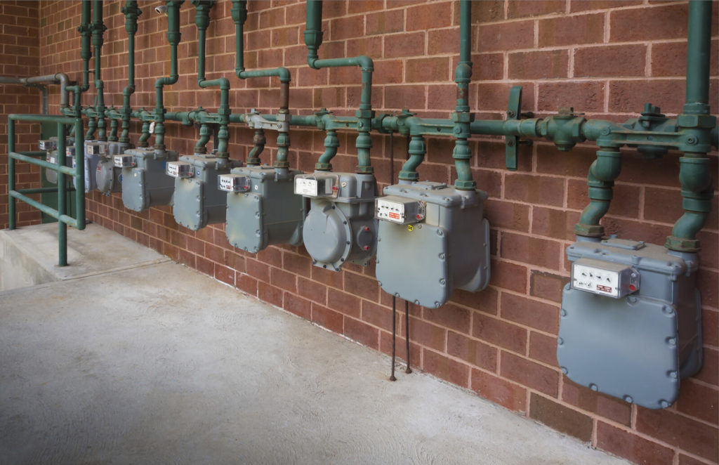 Natural gas specialized flow meters on brick wall.